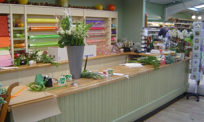 Flower shop counter with light wood accents and display area