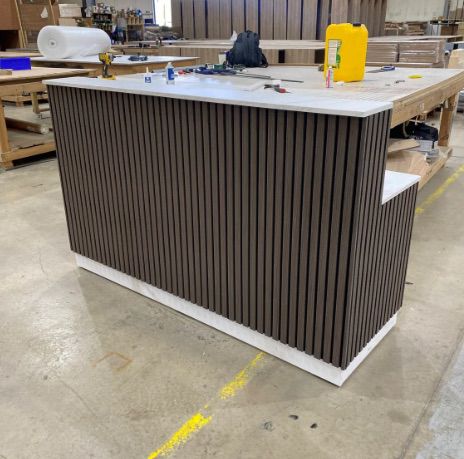 Custom counter with dark wood vertical slats in production